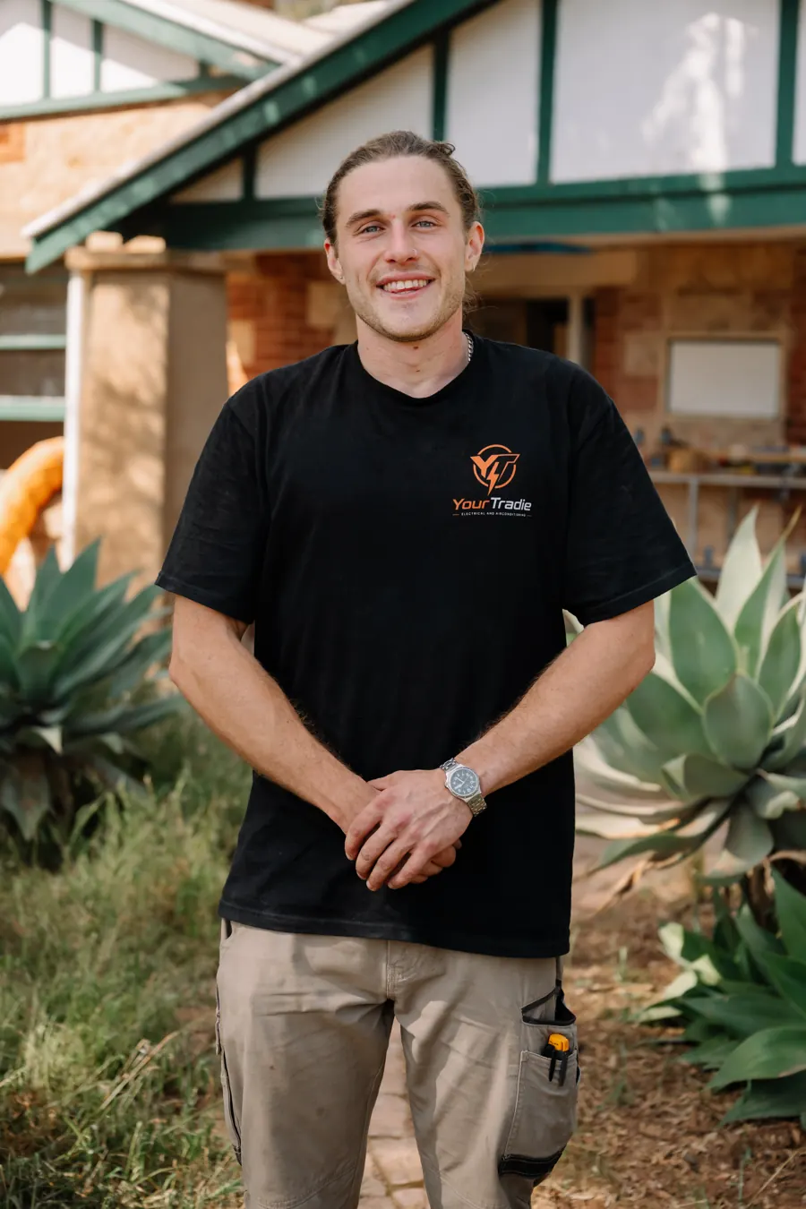 James, owner of YourTradie, standing in a front garden in his work gear